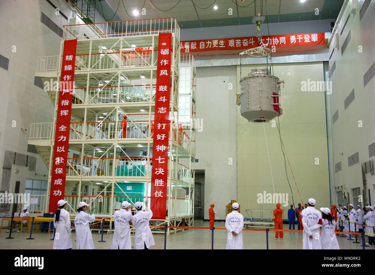 Chinese aeronautical scientists lift the orbital module (capsule) to assemble it with the re-entry module (capsule) of the Shenzhou VII manned spacecr Stock Photo