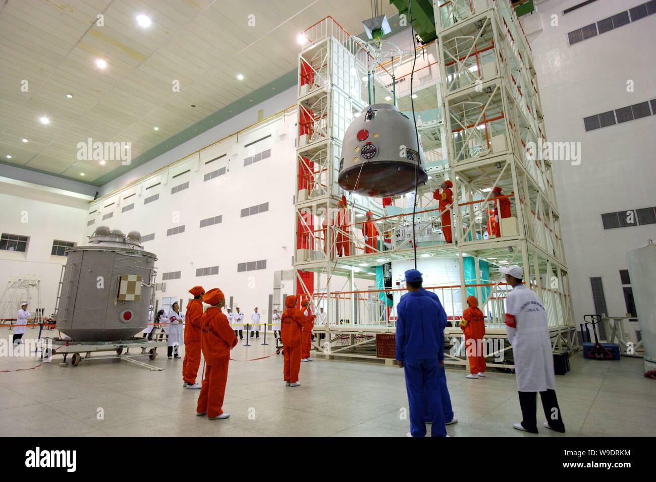 Chinese aeronautical scientists lift the re-entry module (capsule) to assemble it with the propelling module (capsule) of the Shenzhou VII manned spac Stock Photo