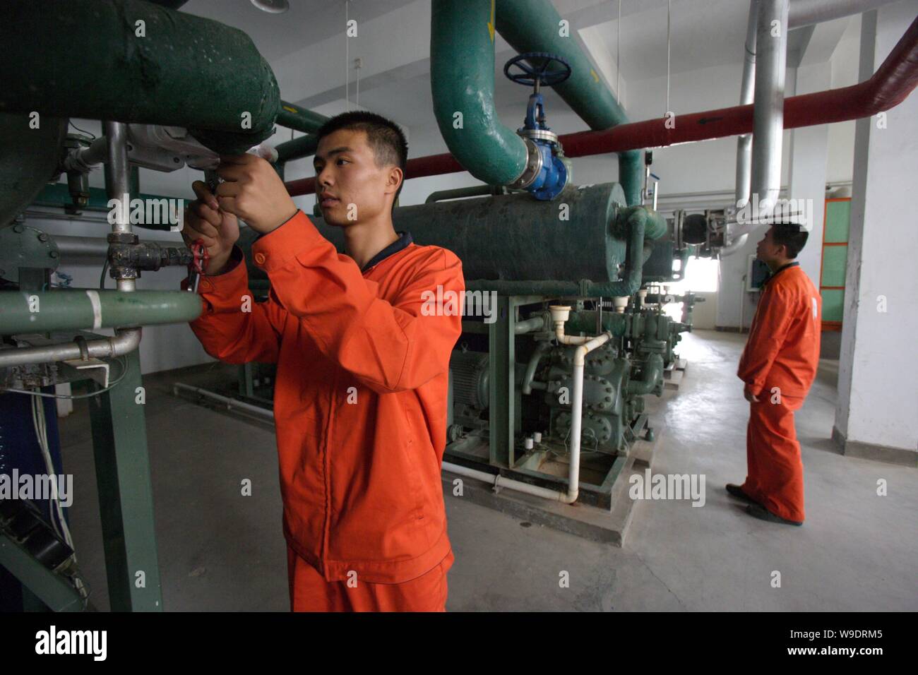 Chinese fuel supply workers check fuel supply compressors in preparation for fuelling a Long March 2F (CZ-2F) space rocket for the Shenzhou VII manned Stock Photo