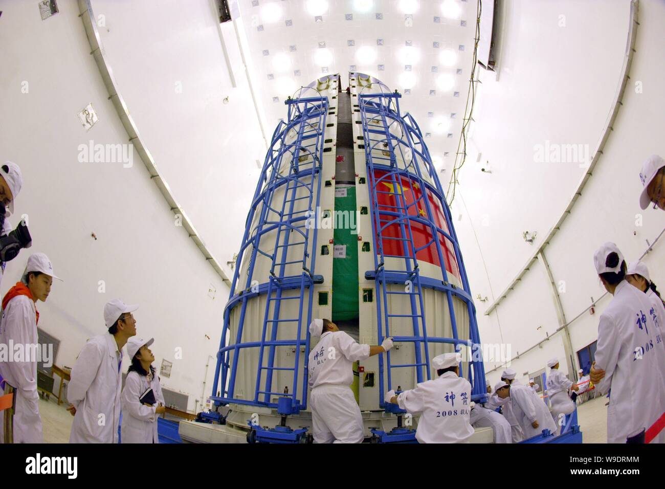 Chinese aeronautical scientists fix the Shenzhou VII manned spacecraft covered a fairing at Jiuquan Satellite Launch Center in northwest Chinas Gansu Stock Photo