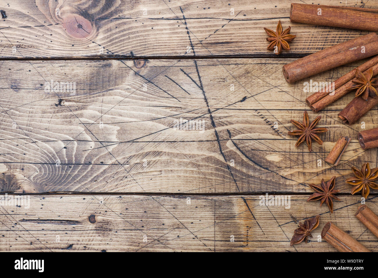 Cinnamon sticks and anise stars on wooden background. Copy space. Top