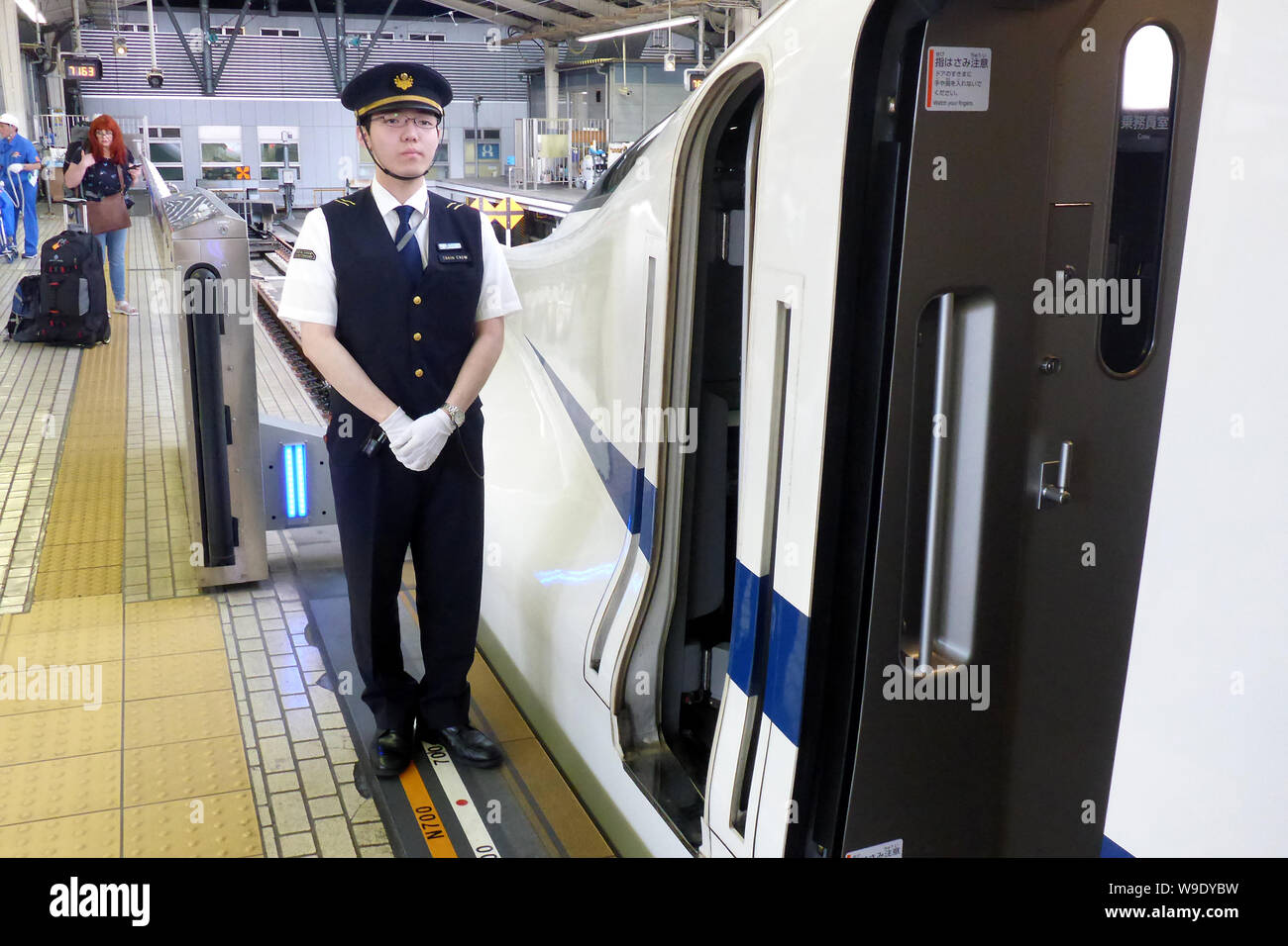 Tokio, Japan. 18th May, 2018. A train attendant is standing next to a Shinkansen Express at the Tokyo railway station at a boarding security system that separates the train from the track bed and thus secures it. Falls into the track bed are not possible in this way. There are similar systems in around 50 other cities around the world, some of which have been in operation since the 1990s - for example in Moscow, London and Barcelona. Credit: Peter Gercke/dpa-Zentralbild/ZB/dpa/Alamy Live News Stock Photo