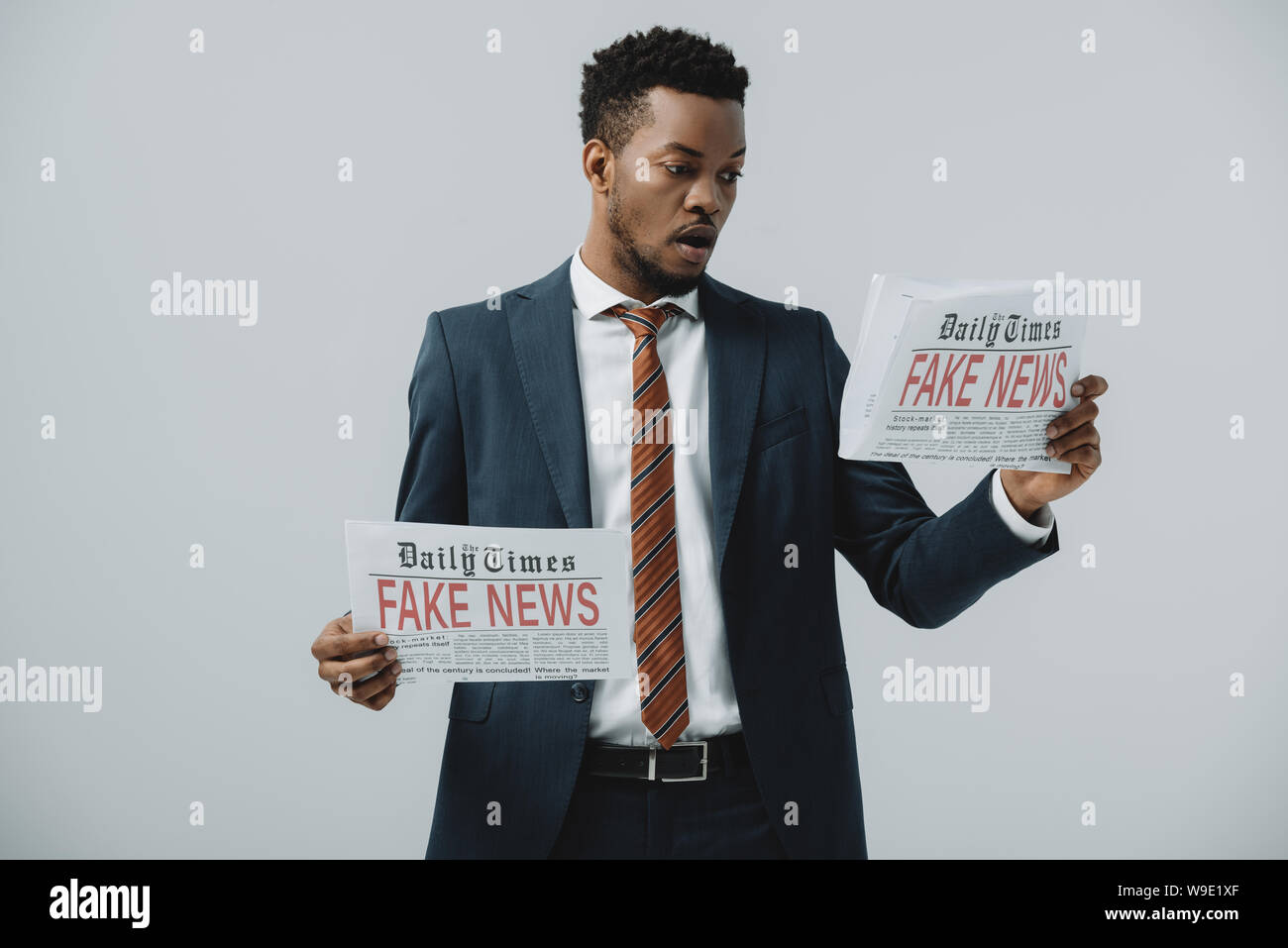 surprised african american businessman reading newspaper with fake news ...