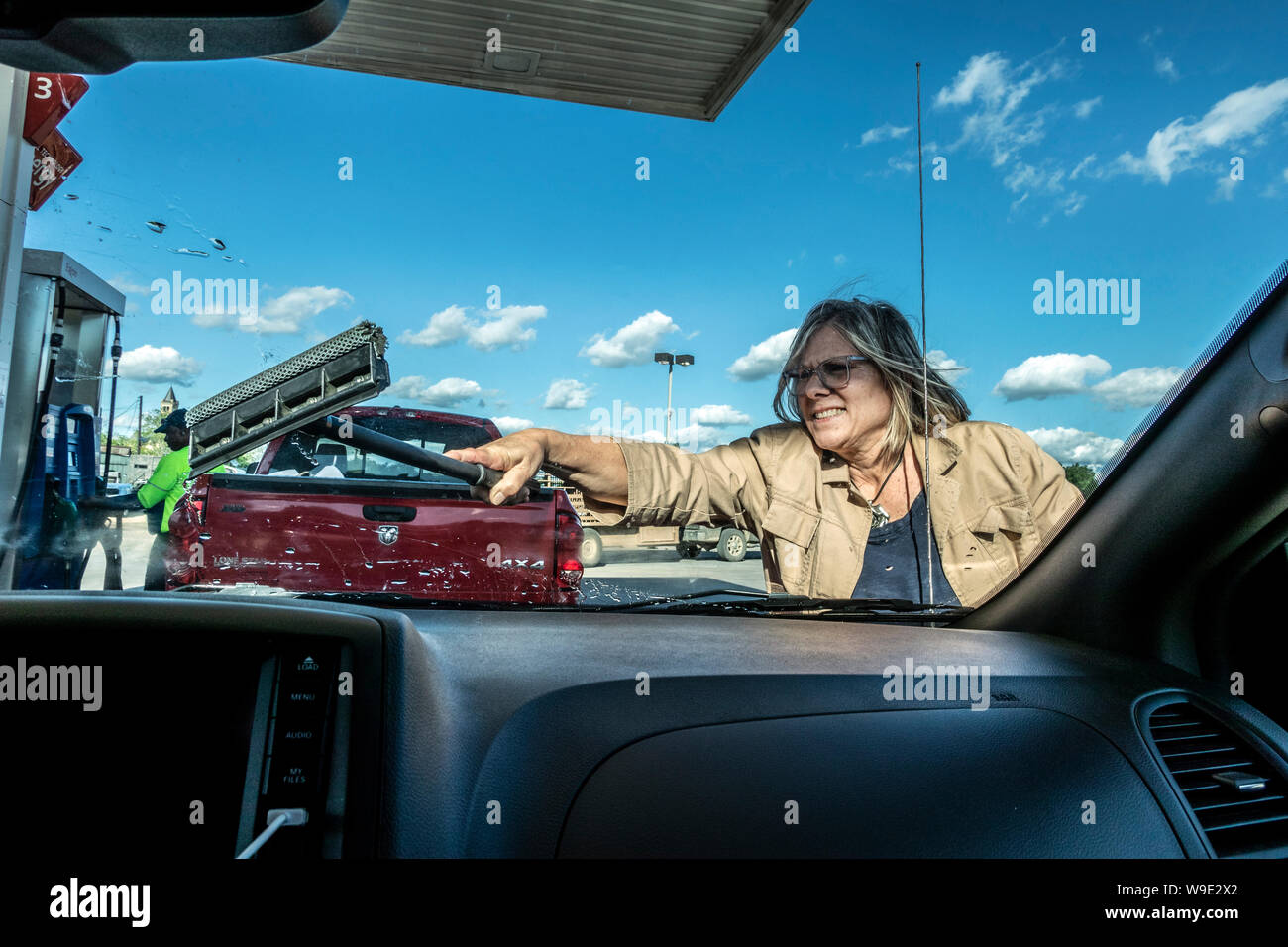 Hand wiping the windshield of a car on a sunny day. Wipe dry with an orange  sponge. Rag wipes water stains on the window Stock Photo - Alamy