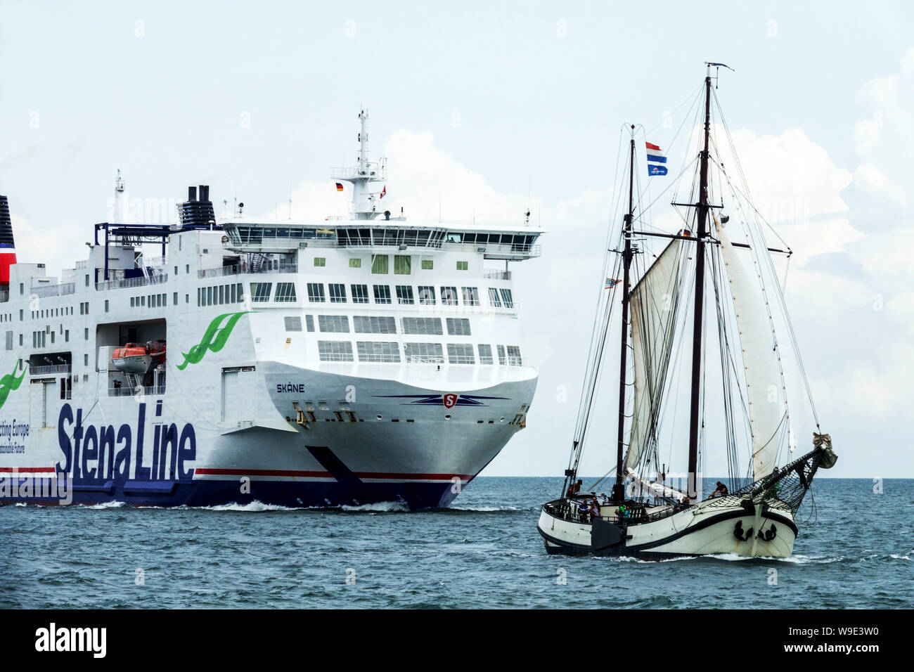 Sailing boat and Stena line ferry approaching the harbor, Rostock Germany Stock Photo
