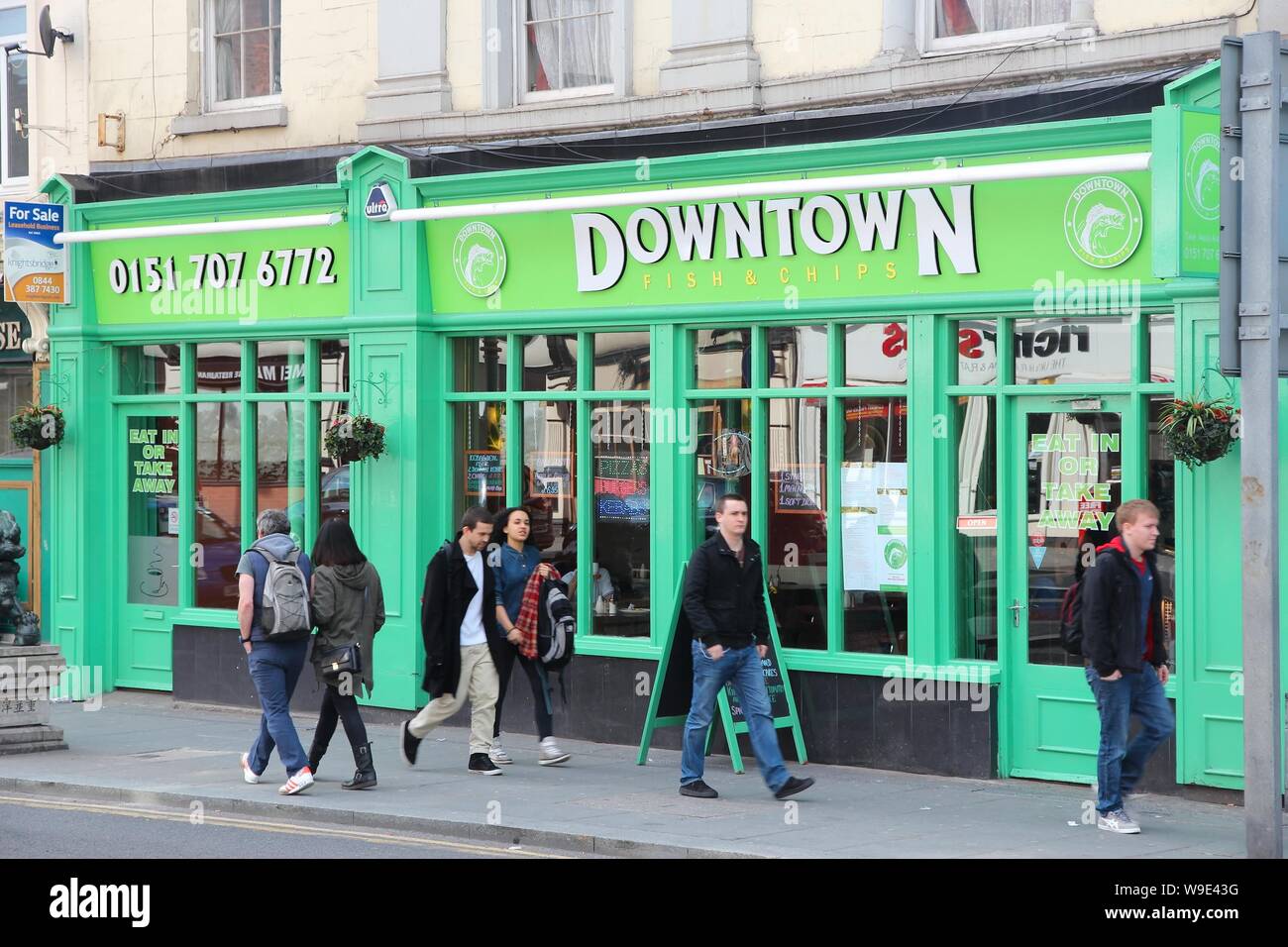 LIVERPOOL, UK - APRIL 20, 2013: People walk by Downtown Fish and Chips restaurant in Liverpool, UK. Fish and chips is a traditional English fast food. Stock Photo
