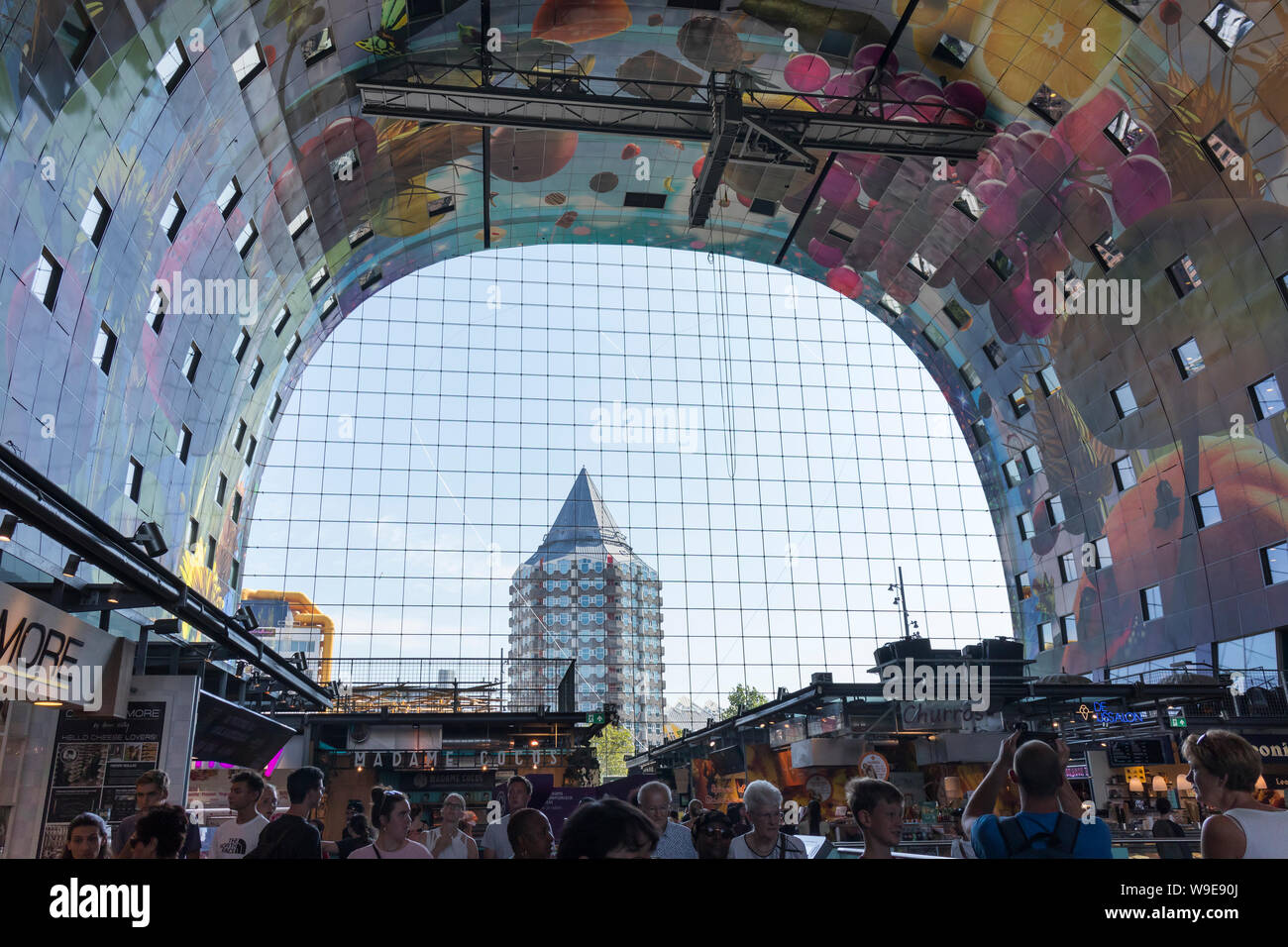 Rotterdam, Holland - July 30, 2019: Artwork at the wall of the Markthal and a view to the pencil building through the glass windows Stock Photo