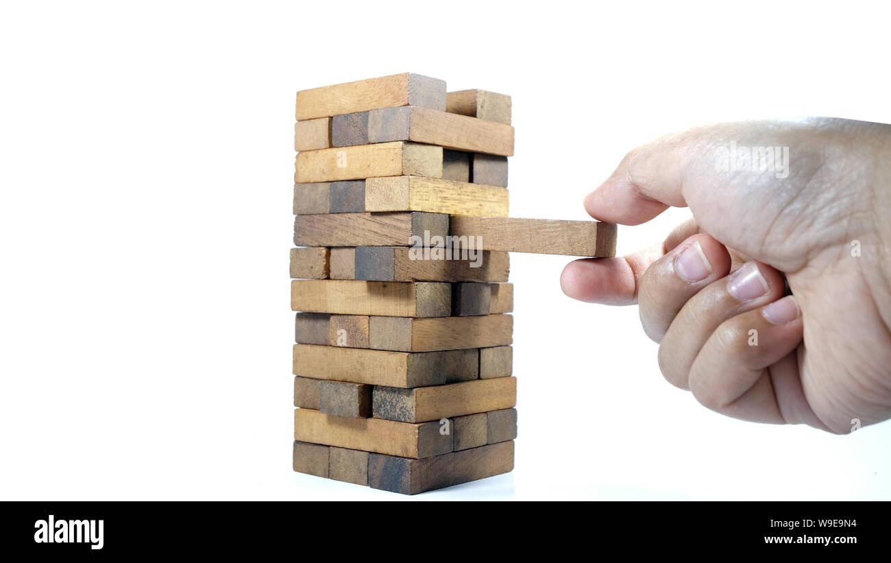 The tower from wooden blocks and man's hand take one block. The game of