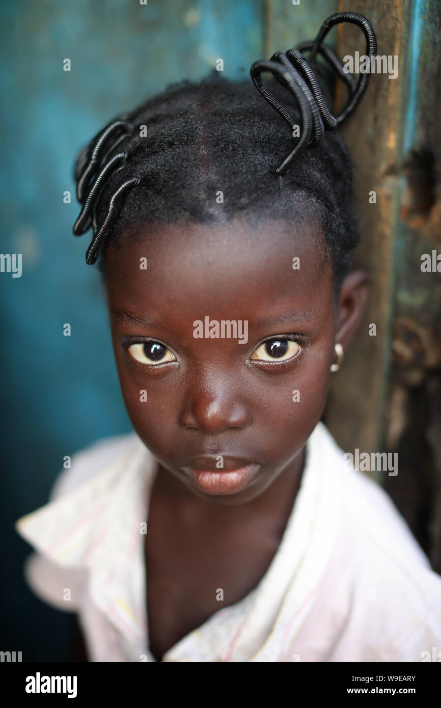 Beautiful girl with nice hairstyle in a slum in the fishing village Jamestown in Accra, Ghana Stock Photo
