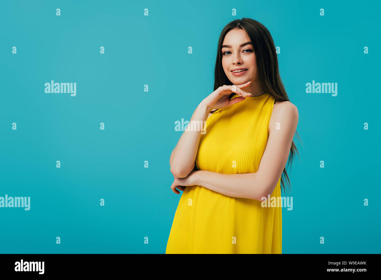 happy beautiful girl in yellow dress touching face isolated on ...