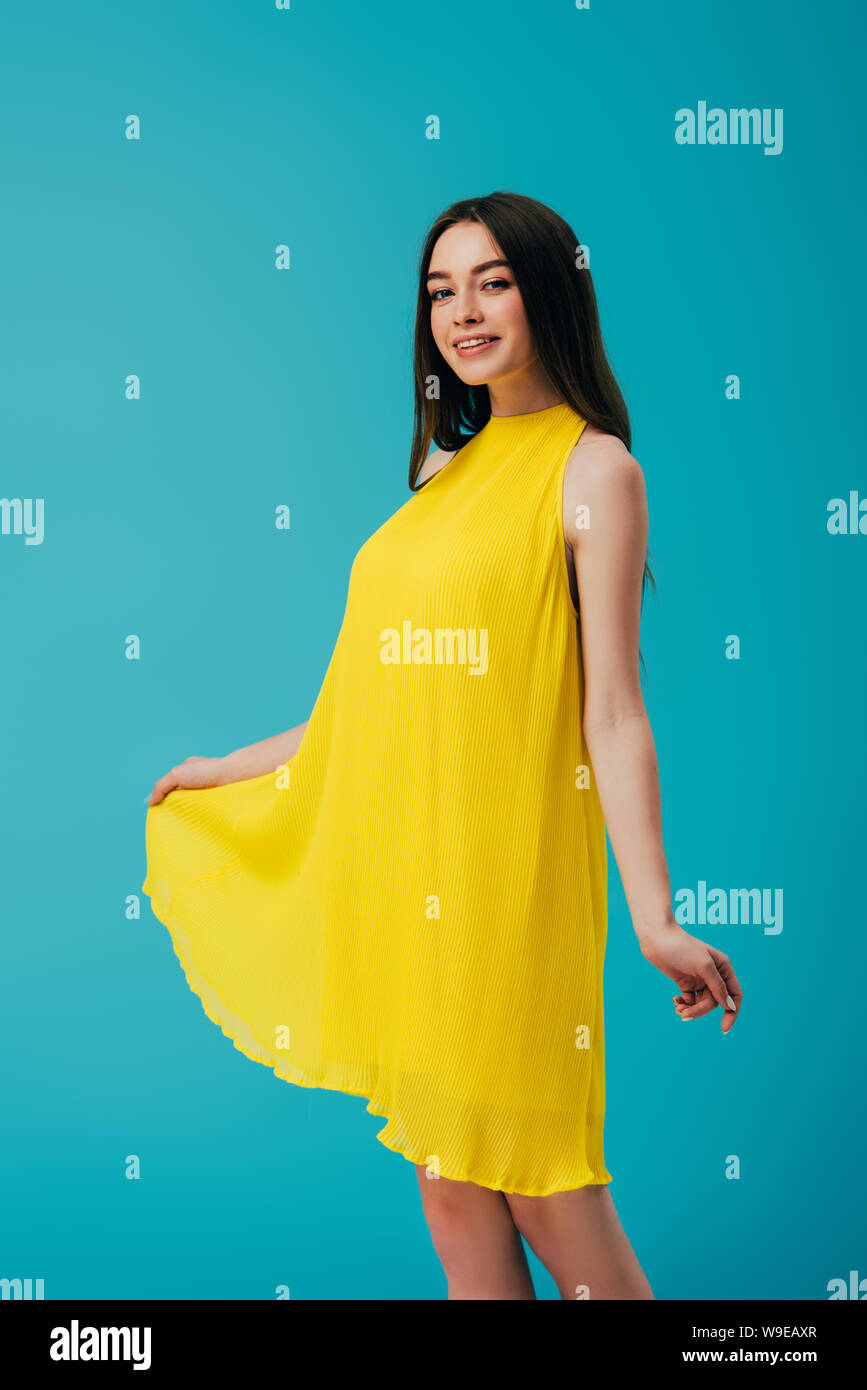happy beautiful girl in yellow dress isolated on turquoise Stock Photo ...