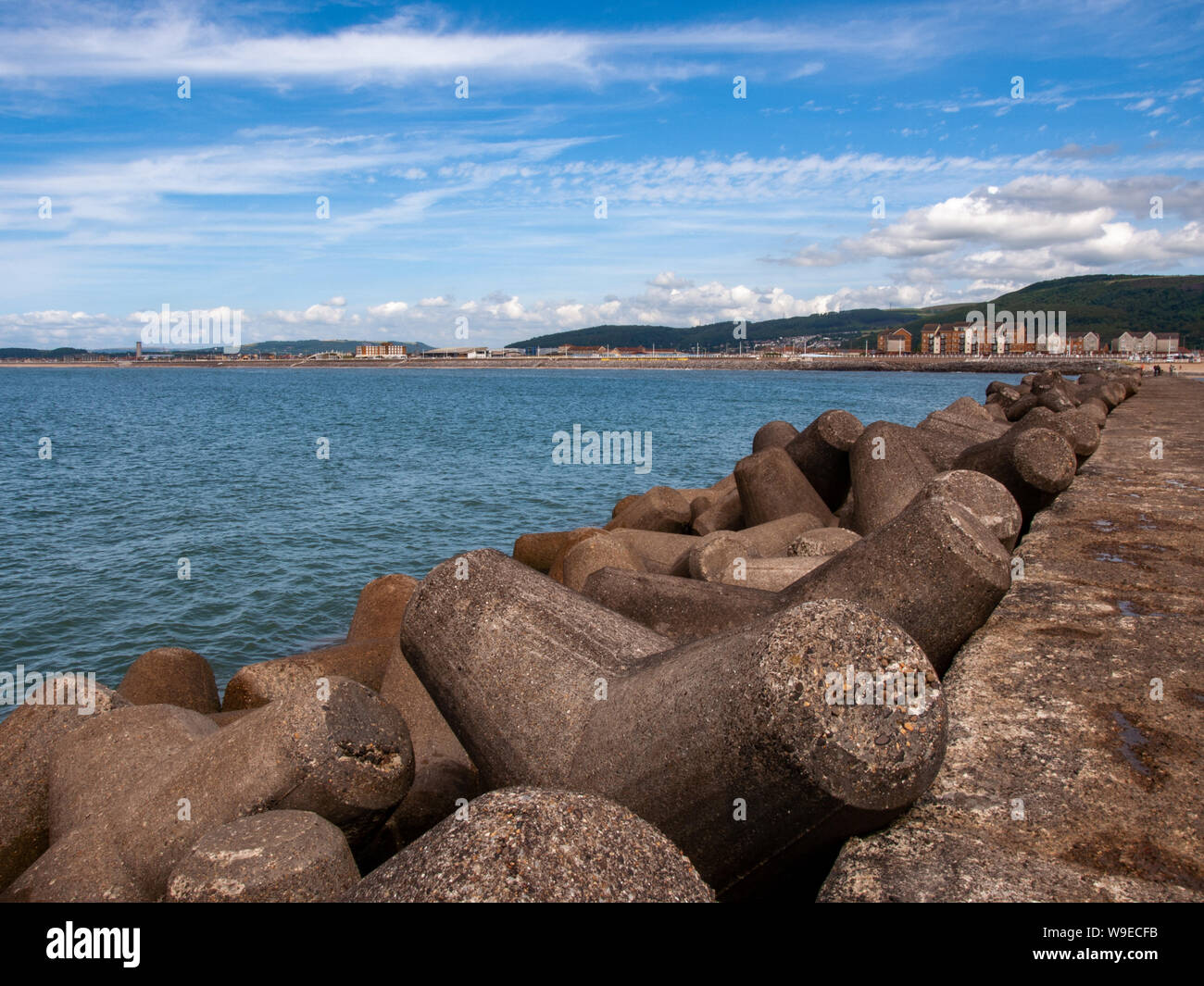 A view from the breakwater looking back to Aberavon Beach. Tetrrapod sea defences can be seen in the foreground. Aberavon, Wales, UK. Stock Photo