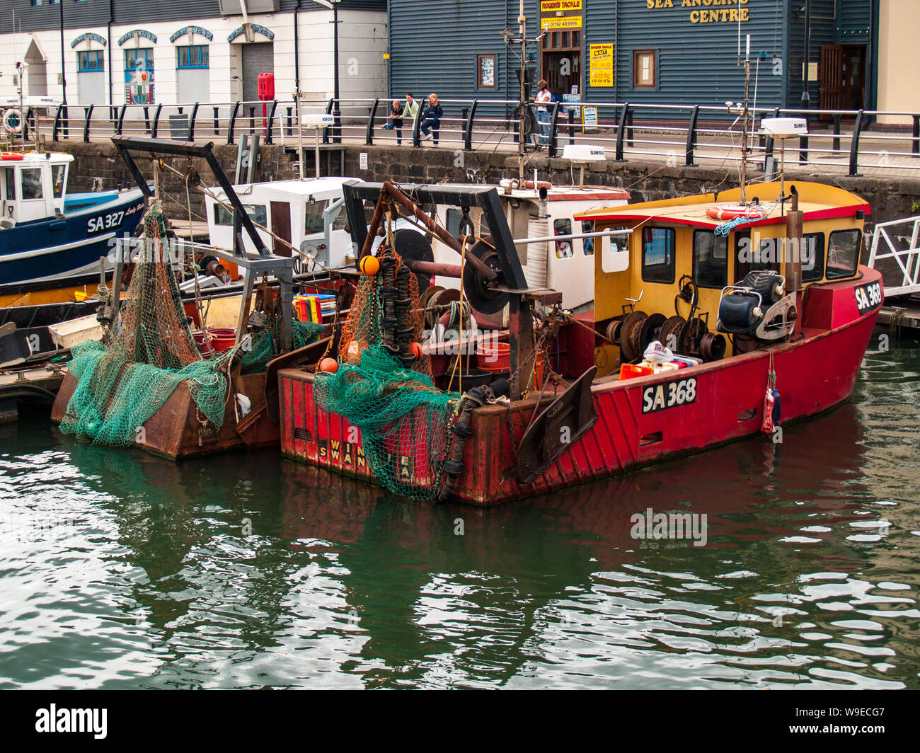 Swansea marina. Fishing boats are tied up at the dock. Fishing equipment and nets can be seen on the boats. Wales, UK. Stock Photo