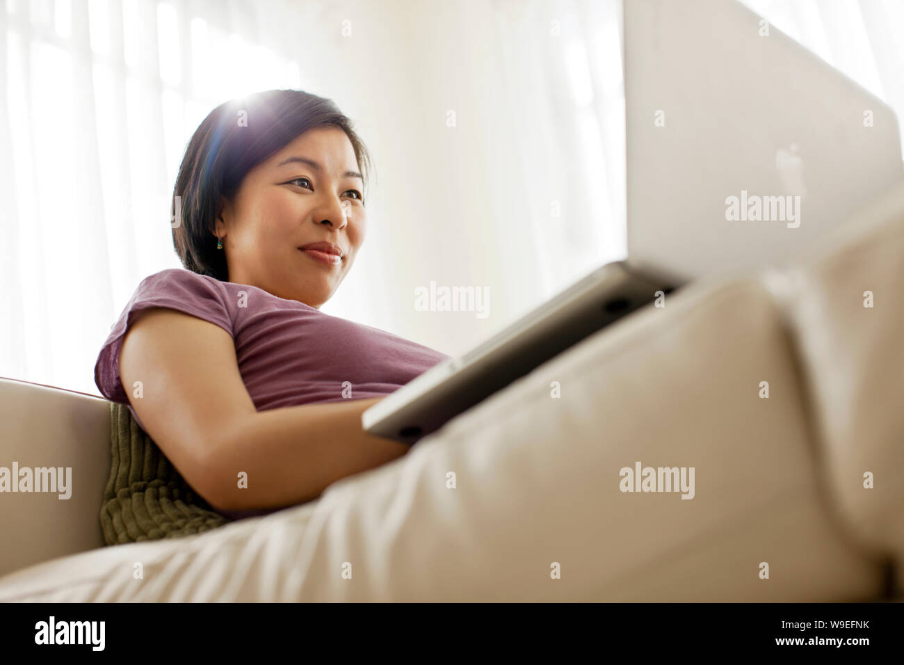Happy young woman using a laptop computer. Stock Photo