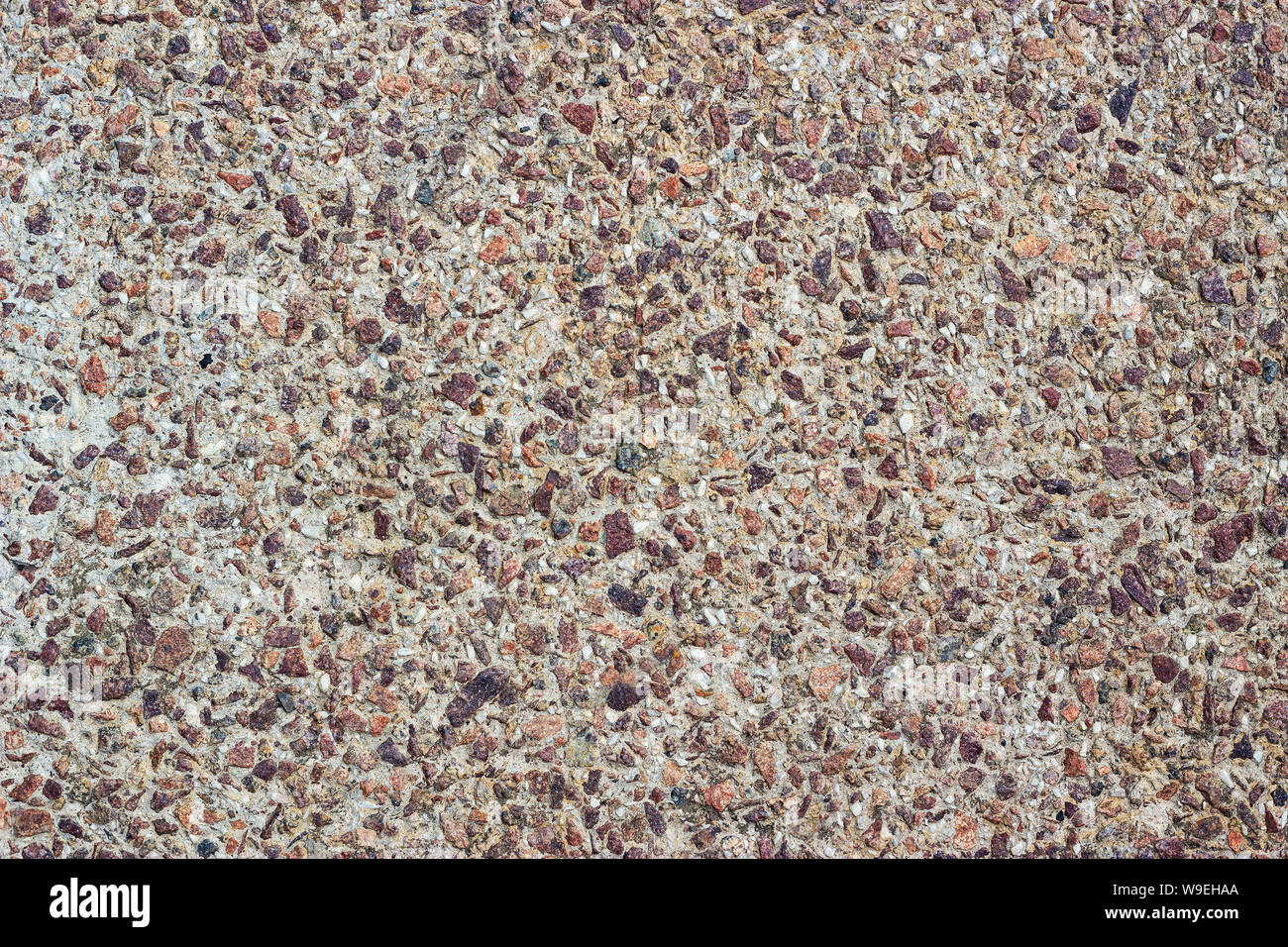 Concrete surface with small pebbles. Small stone wall texture for background. Stock Photo