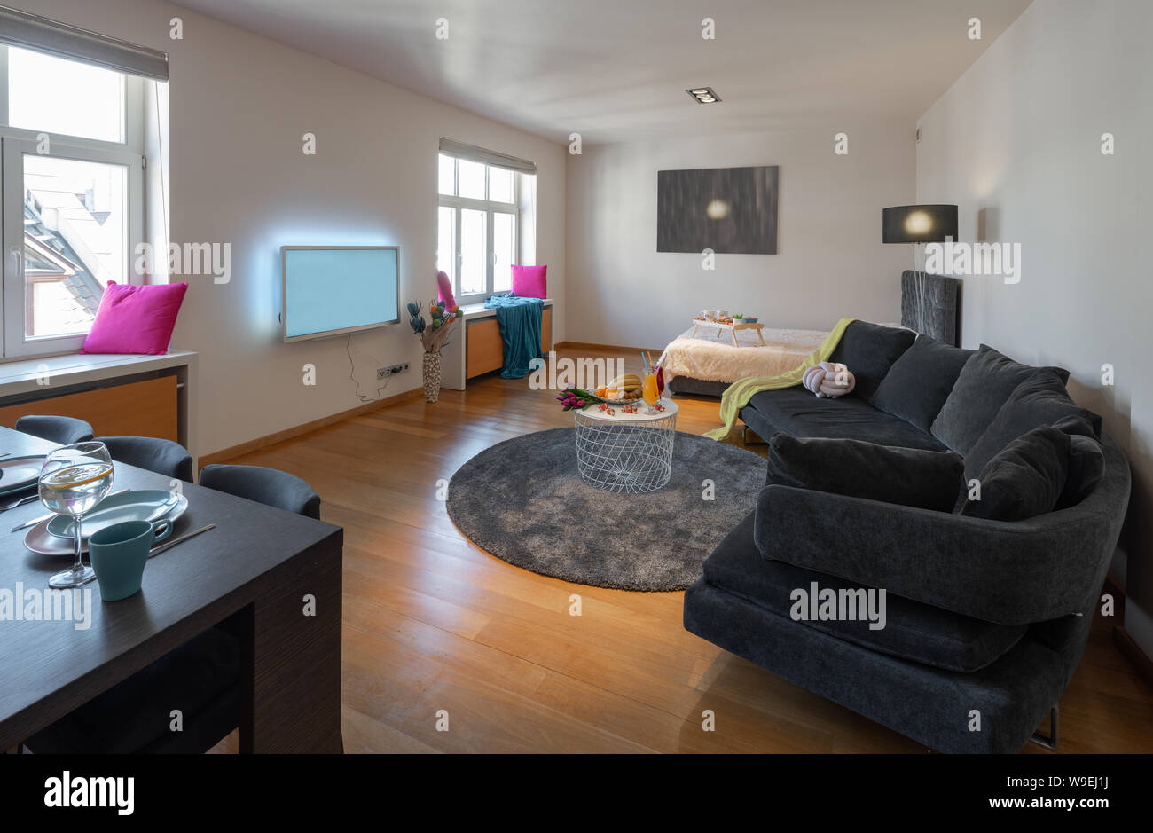 Grey Sofa Bed And Tv In Apartment White Walls Stock Photo