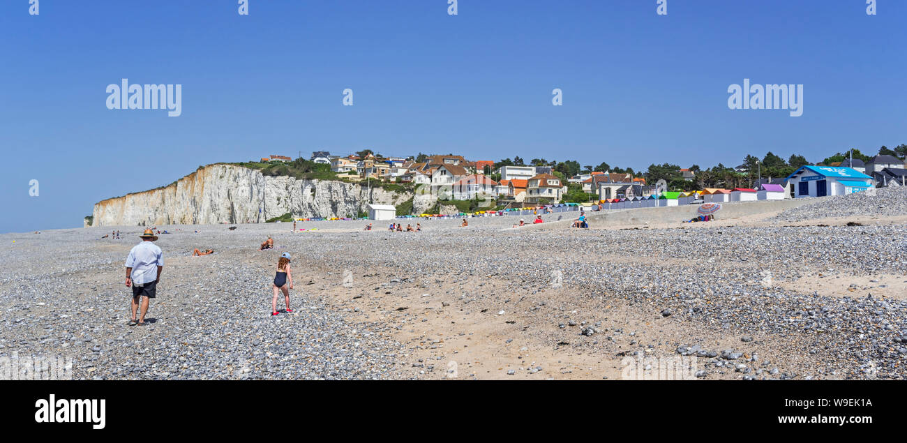 Sunbathers and colourful beach cabins on shingle beach / pebble beach at Criel-sur-Mer in summer, Seine-Maritime, Normandy, France Stock Photo
