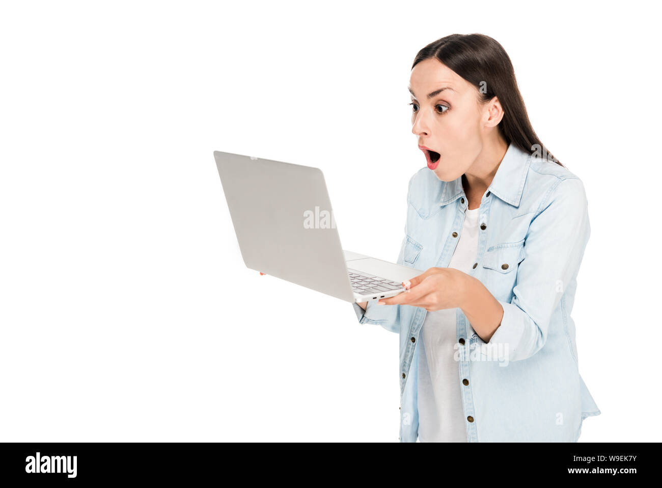shocked girl in denim jacket using laptop isolated on white Stock Photo