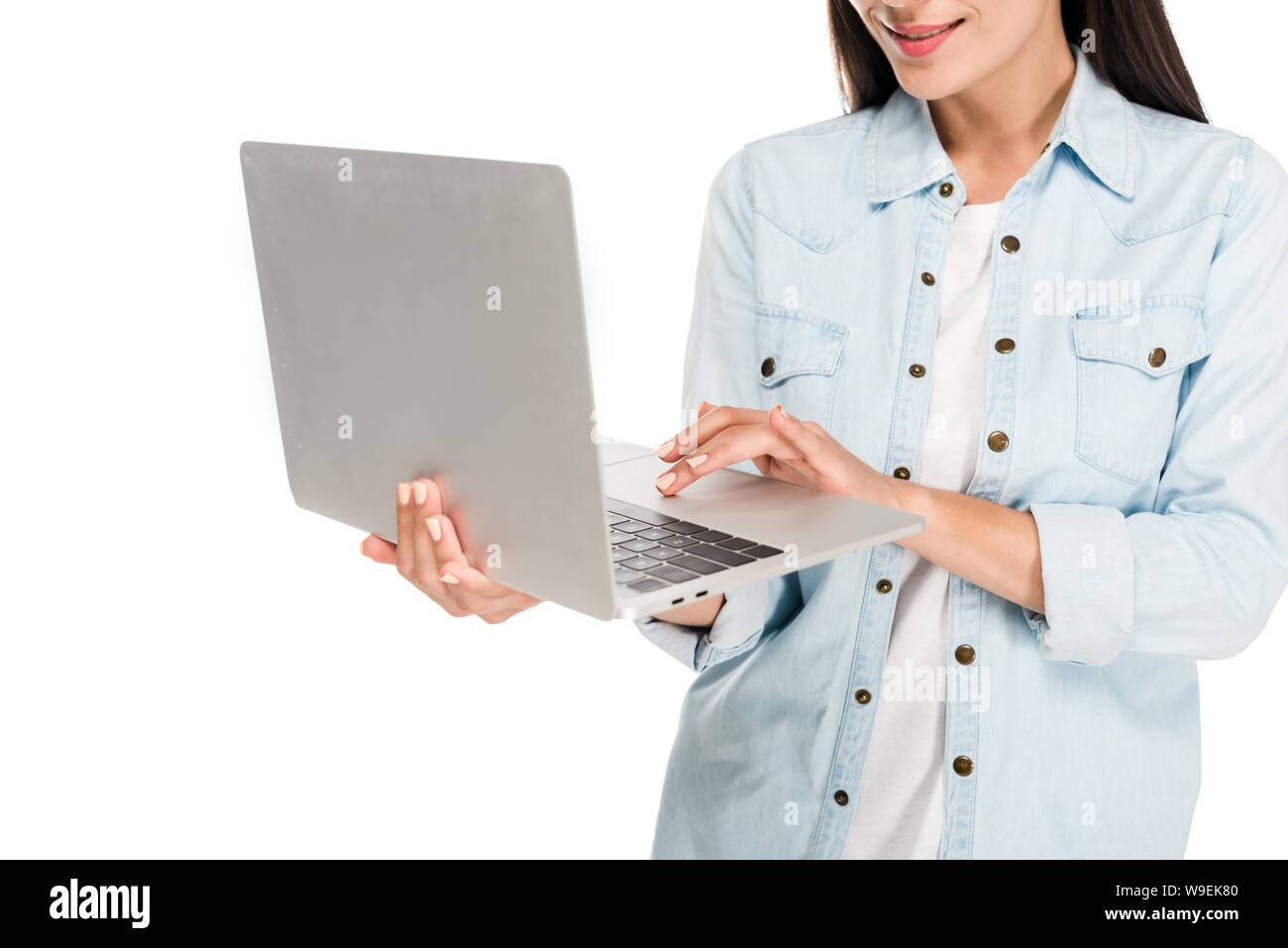 partial view of smiling girl in denim jacket using laptop isolated on white Stock Photo