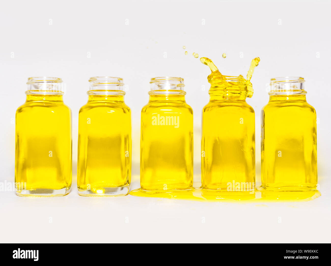 Bottles filled with yellow fluid, one is splashing Stock Photo Alamy