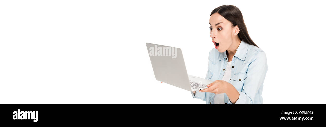shocked girl in denim jacket using laptop isolated on white, panoramic shot Stock Photo