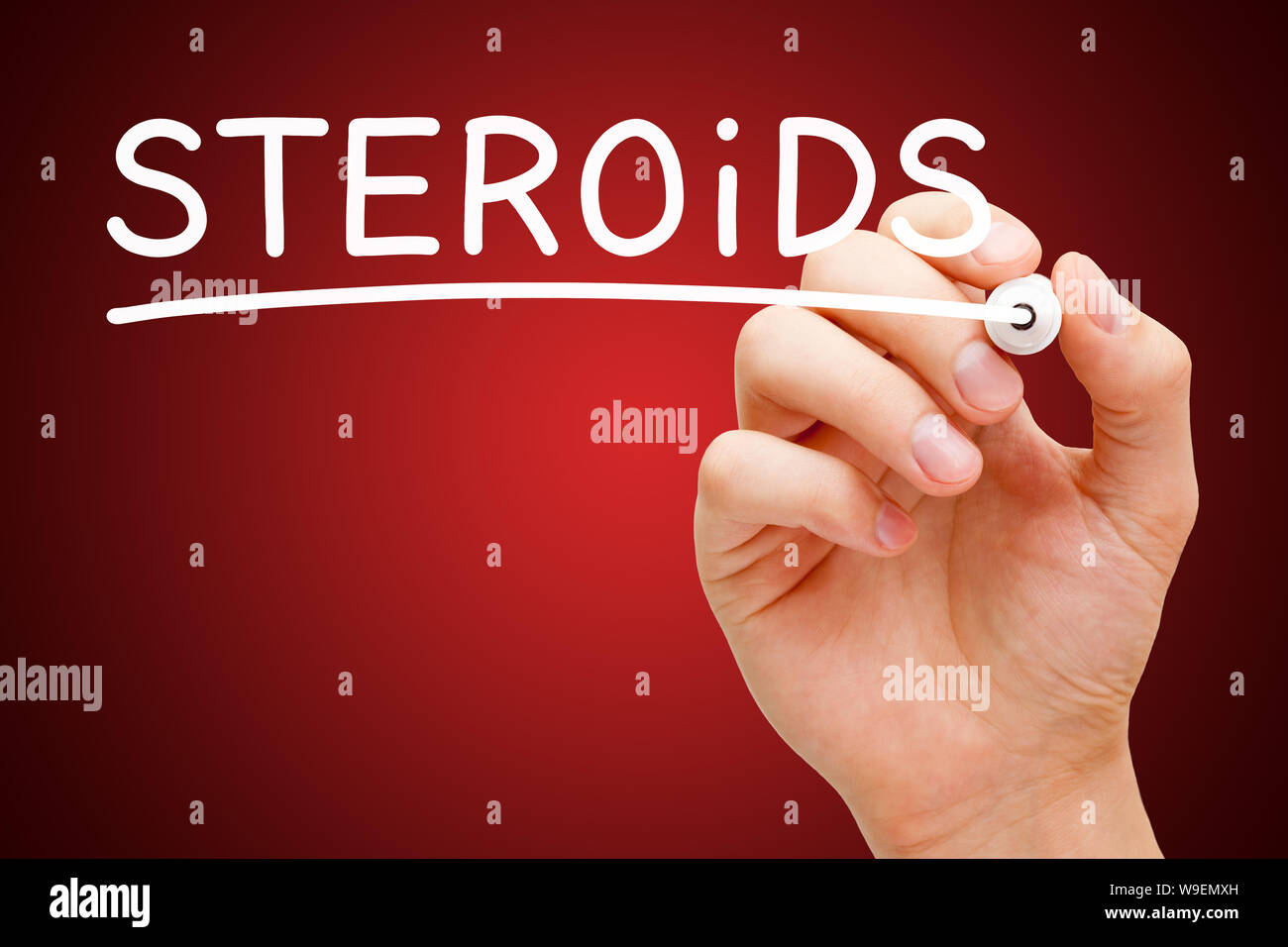 Hand writing word Steroids with white marker on transparent wipe board on dark red background. Stock Photo