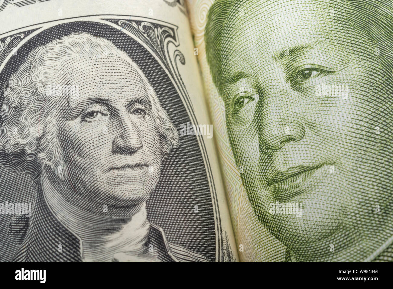 Macro close-up shot U.S. 1 Dollar bill banknote with Chinese Yuan 1 Renminbi banknote. Metaphor US-China trade war, currency manipulation. Stock Photo