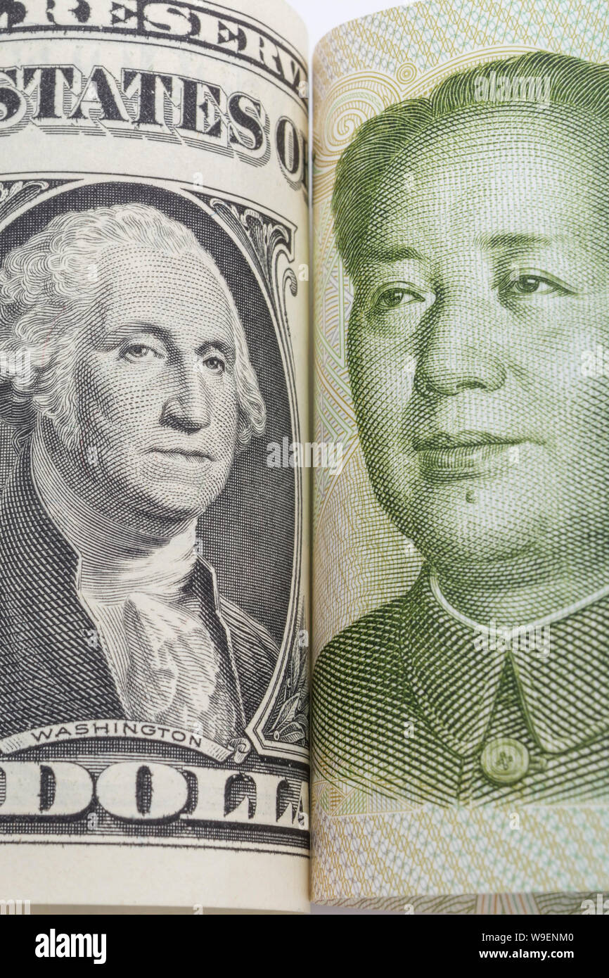 Macro close-up shot U.S. 1 Dollar bill banknote with Chinese Yuan 1 Renminbi banknote. Metaphor US-China trade war, currency manipulation. Stock Photo