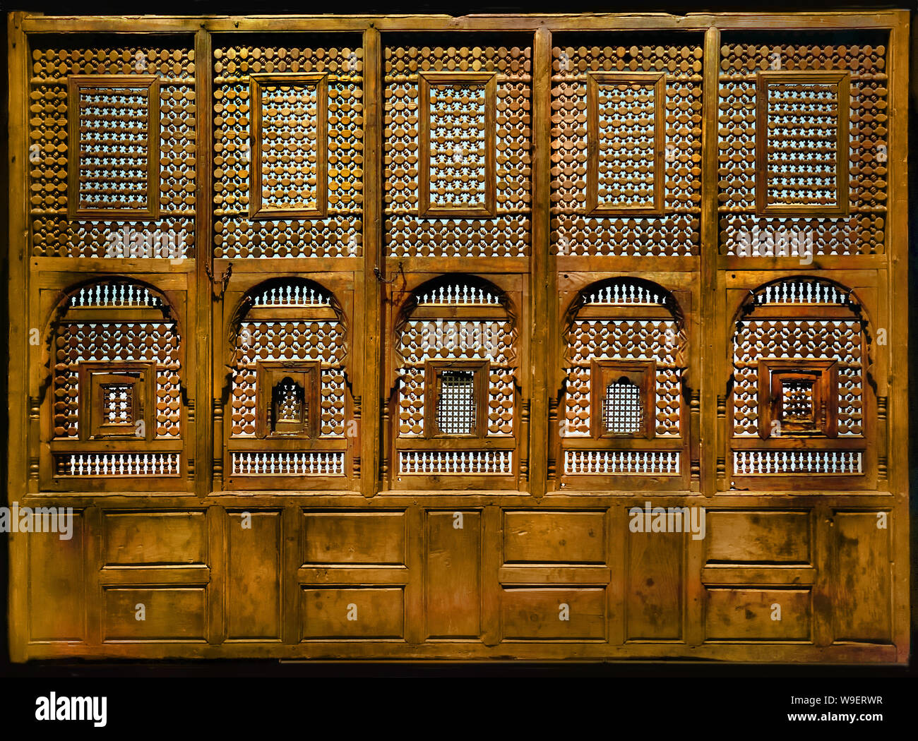Moucharabieh 18th century Egypt Turned wood Ottoman Egypt, 1516-1882 In the Arab provinces of the Empire, local architectural traditions continue. The Ottoman influence is primarily present in the decorative vocabulary, such as floral ornaments in stained glass or furniture. The moucharabiehs are a characteristic of Egyptian architecture. These skylights of turned wood allow both to ventilate the interiors while filtering the light and therefore the heat, and also to see without being seen. Stock Photo
