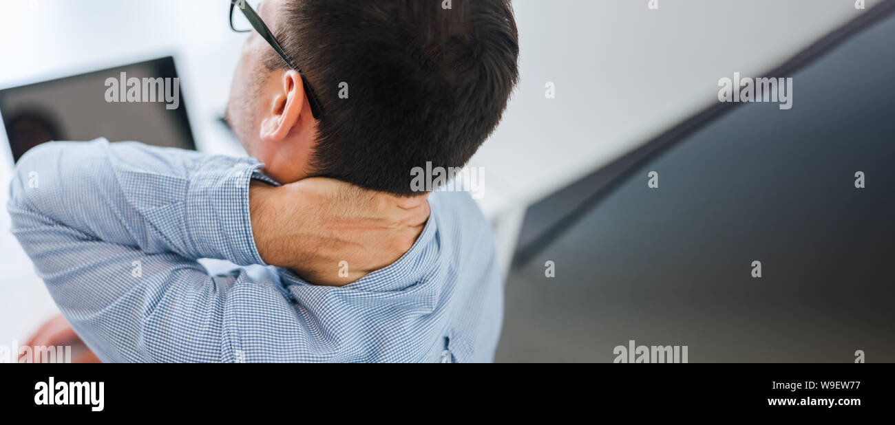 Businessman office worker holding sore neck pain from desk working and