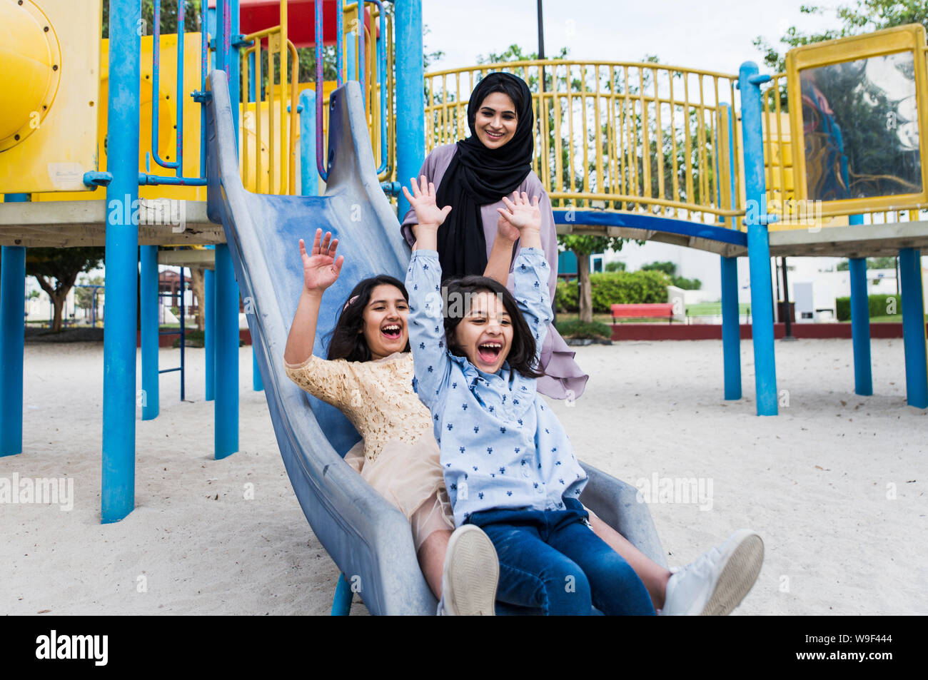 Mom and daughters spending time together at the park, in Dubai Stock