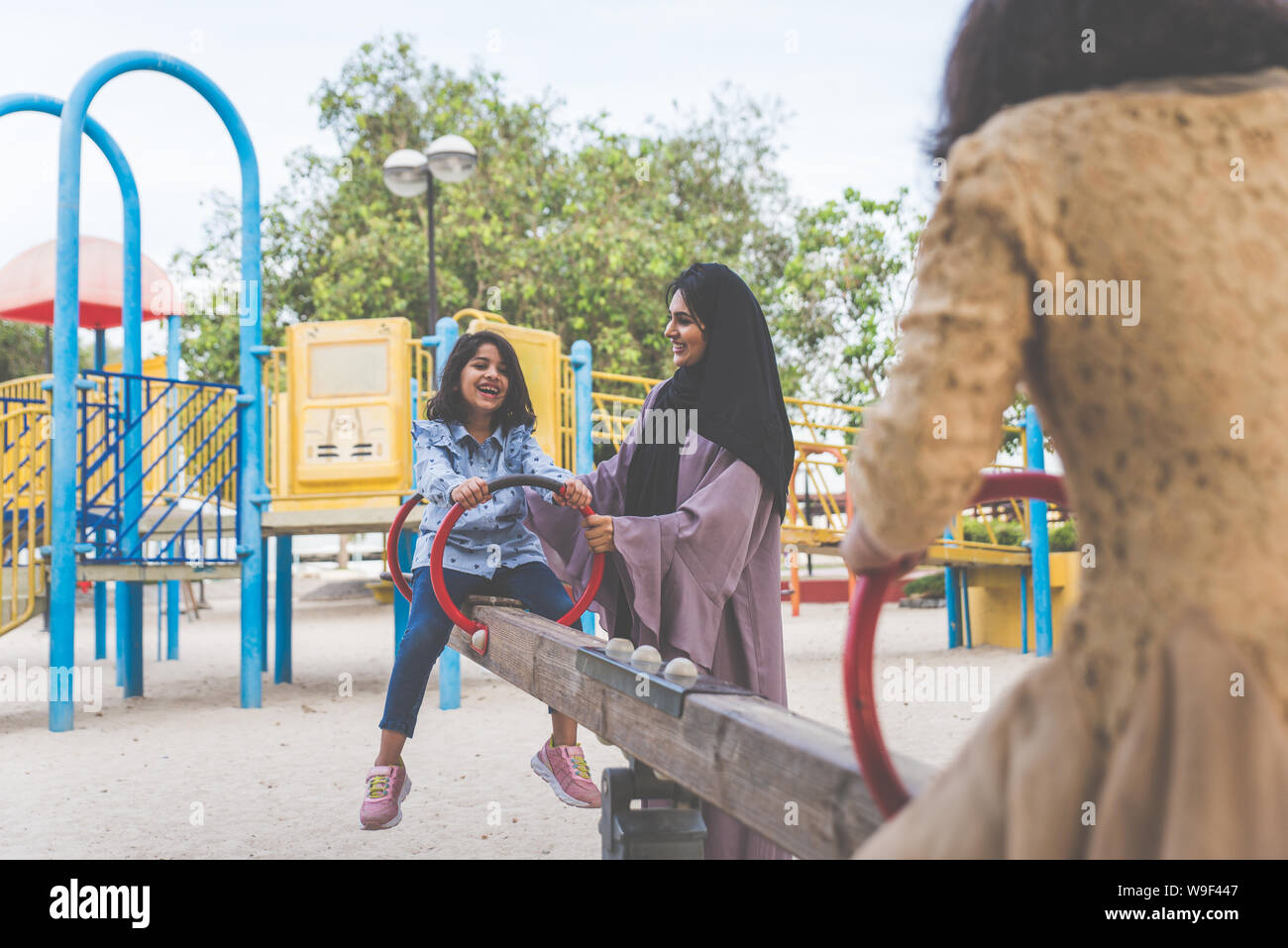 Mom and daughters spending time together at the park, in Dubai Stock