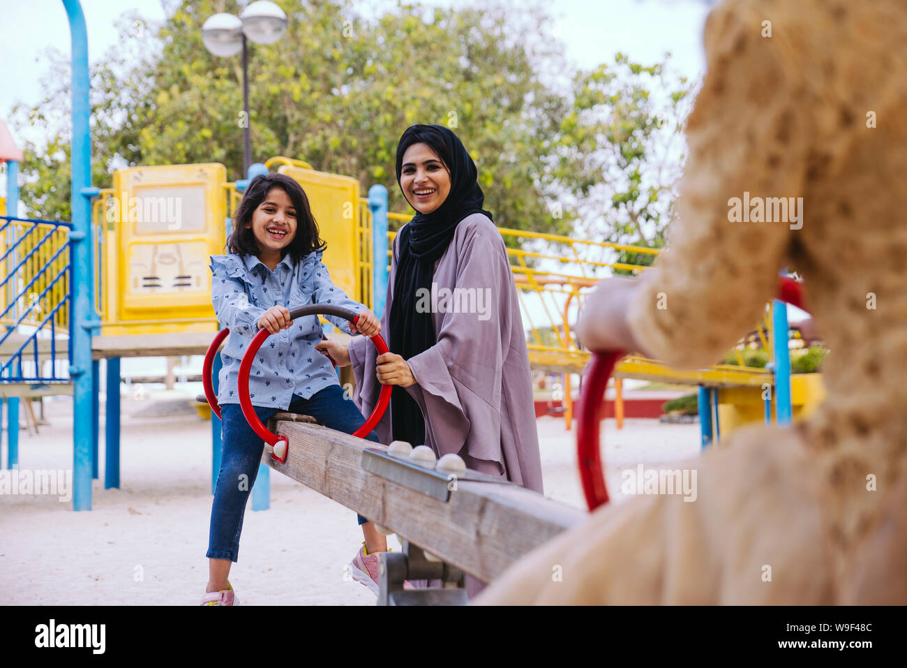 Mom and daughters spending time together at the park, in Dubai Stock