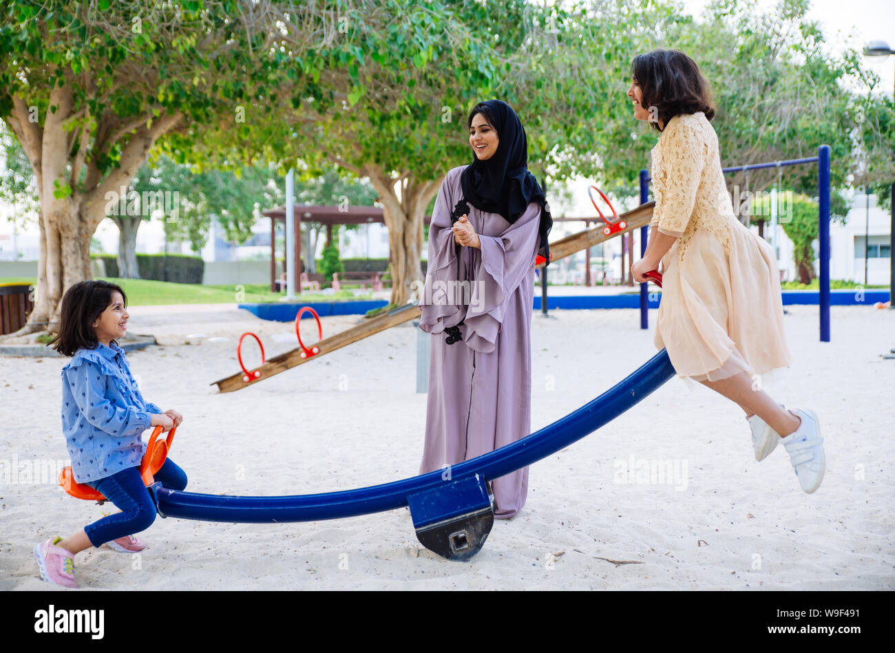 Mom and daughters spending time together at the park, in Dubai Stock