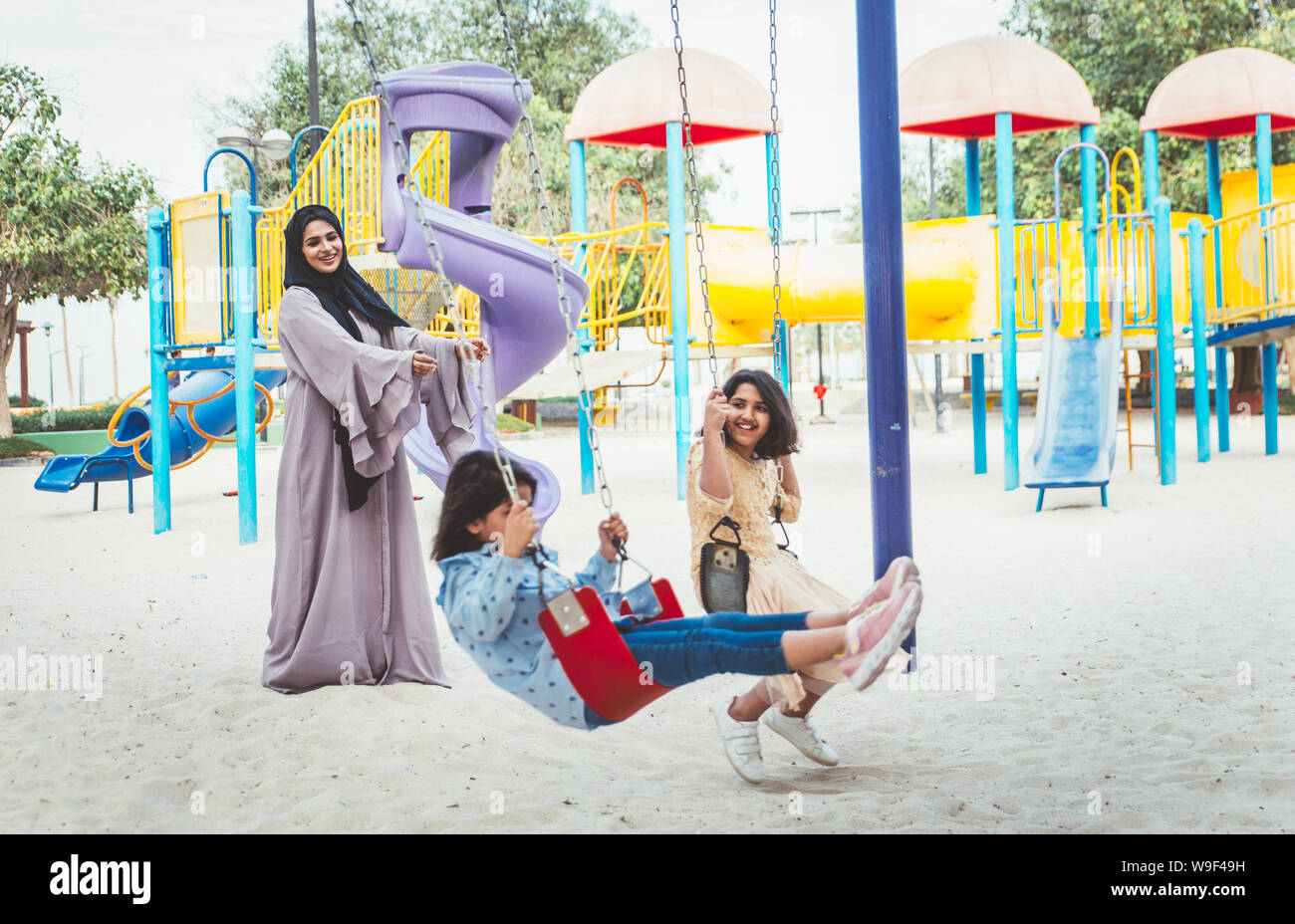 Mom and daughters spending time together at the park, in Dubai Stock