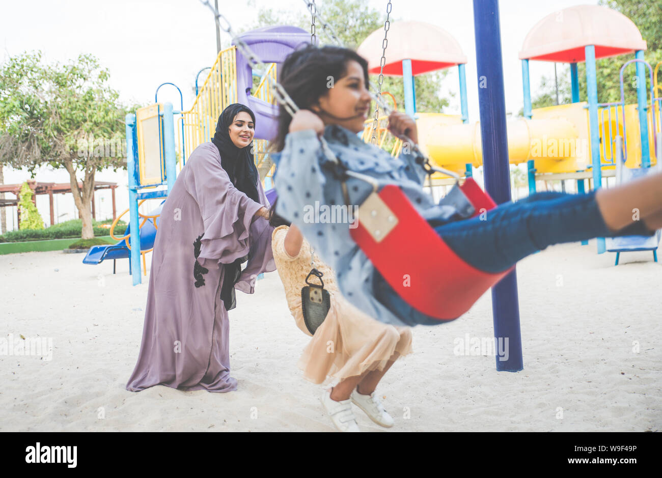 Mom and daughters spending time together at the park, in Dubai Stock