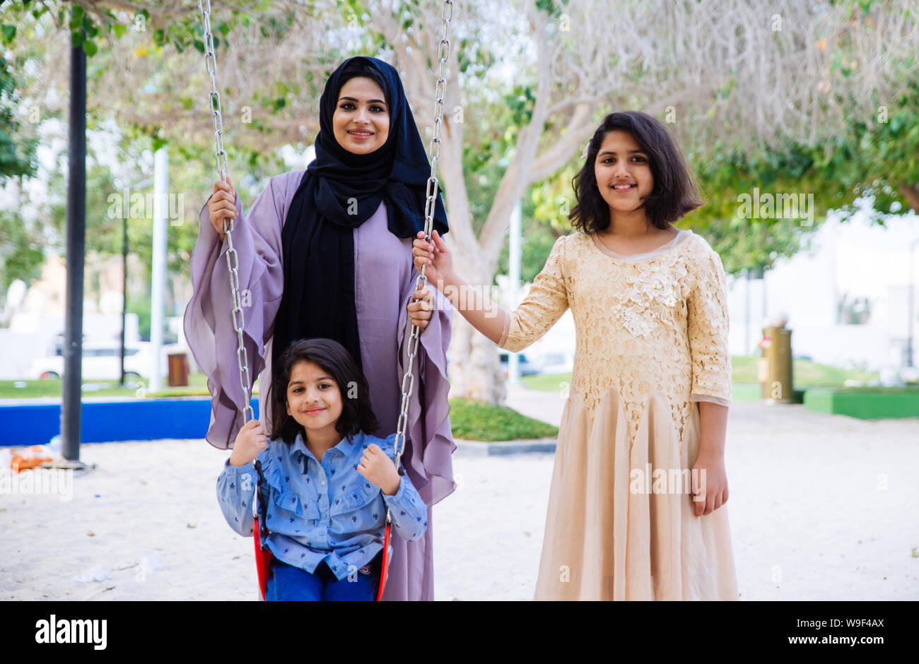 Mom and daughters spending time together at the park, in Dubai Stock