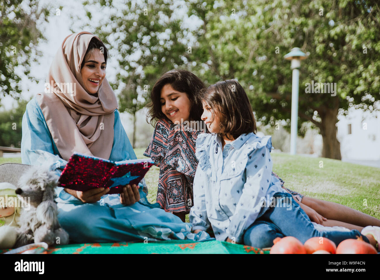 Mom and daughters spending time together at the park, in Dubai Stock