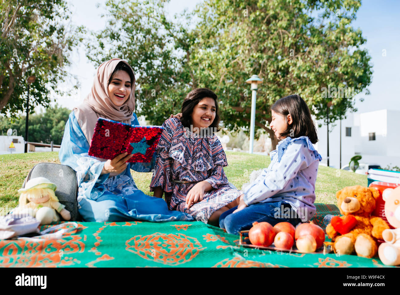 Mom and daughters spending time together at the park, in Dubai Stock