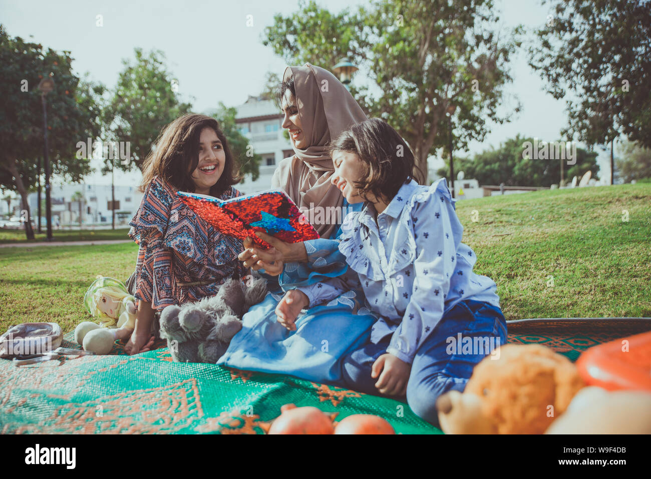 Mom and daughters spending time together at the park, in Dubai Stock