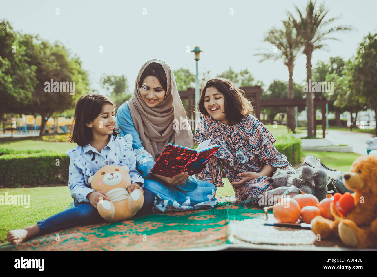 Mom and daughters spending time together at the park, in Dubai Stock