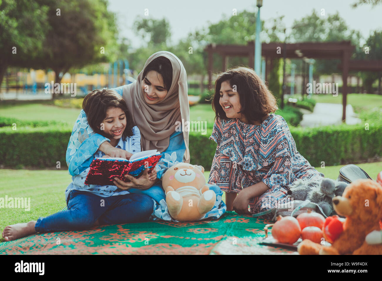 Mom and daughters spending time together at the park, in Dubai Stock