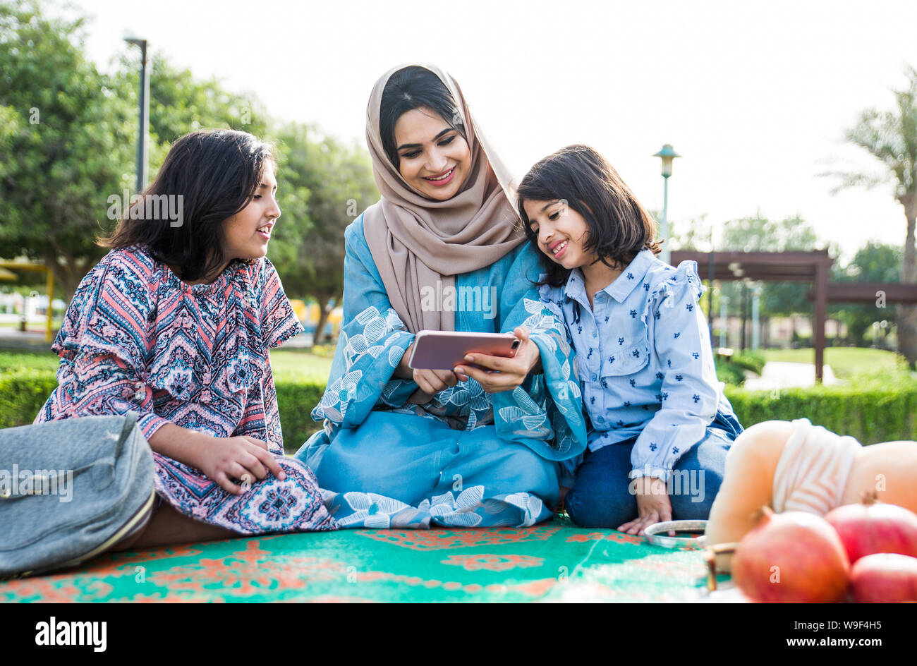 Mom and daughters spending time together at the park, in Dubai Stock