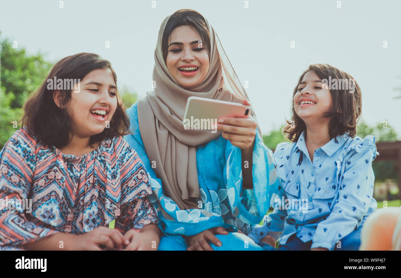 Mom and daughters spending time together at the park, in Dubai Stock