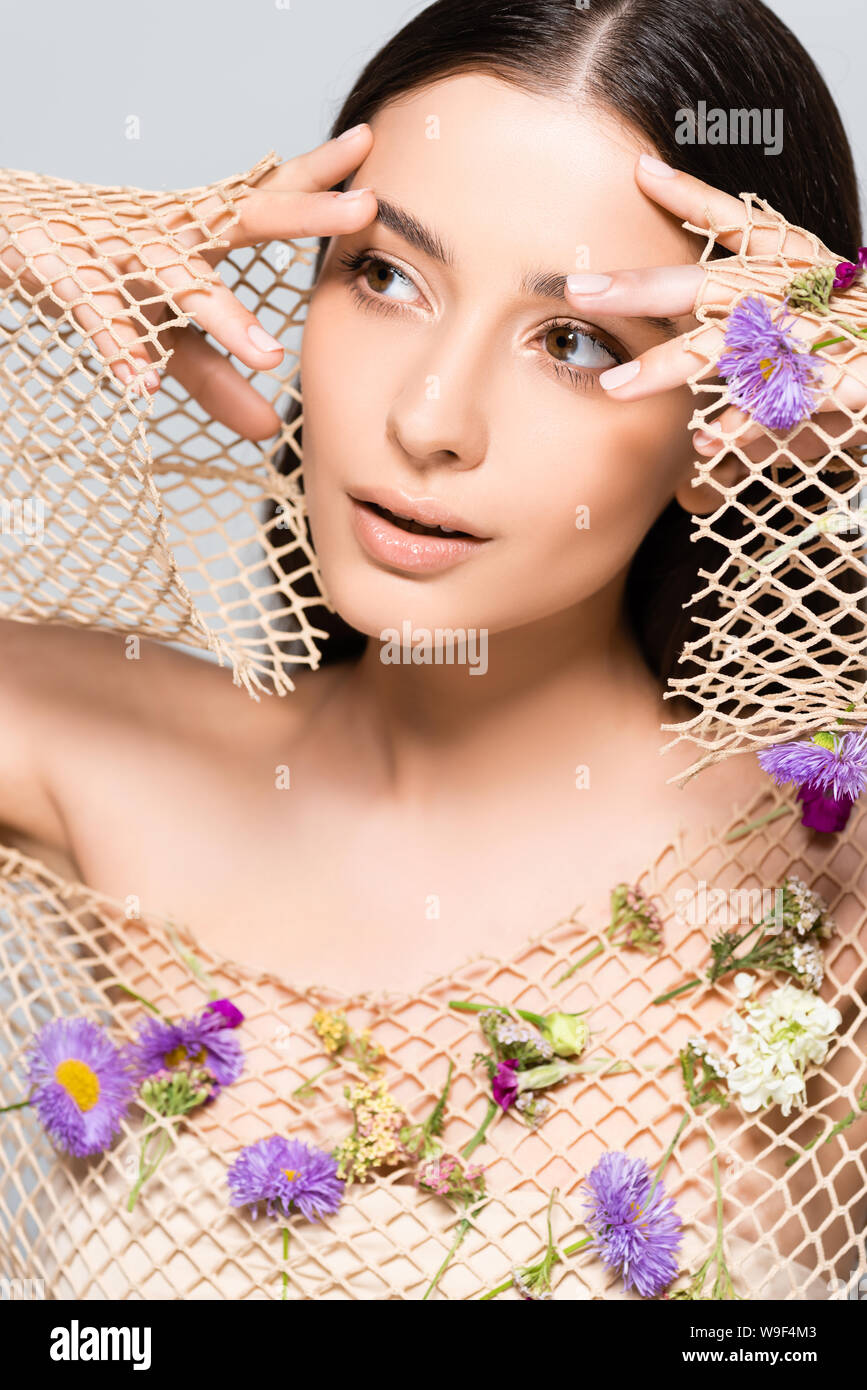 beautiful woman in mesh beige clothing with purple flowers posing ...