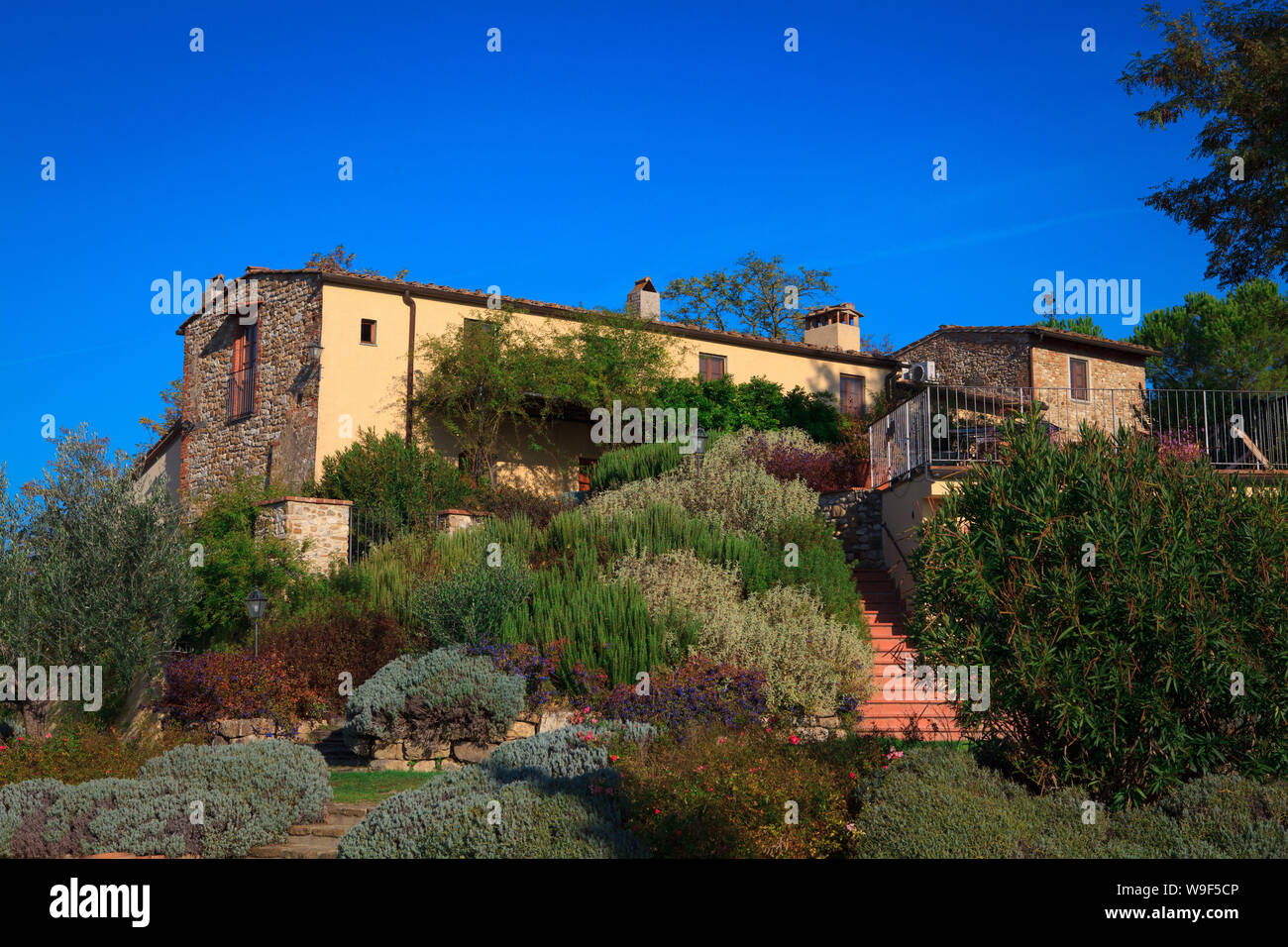 Typical Italian rural house with restaurant in lush vegetation in the afternoon in summer. Stock Photo