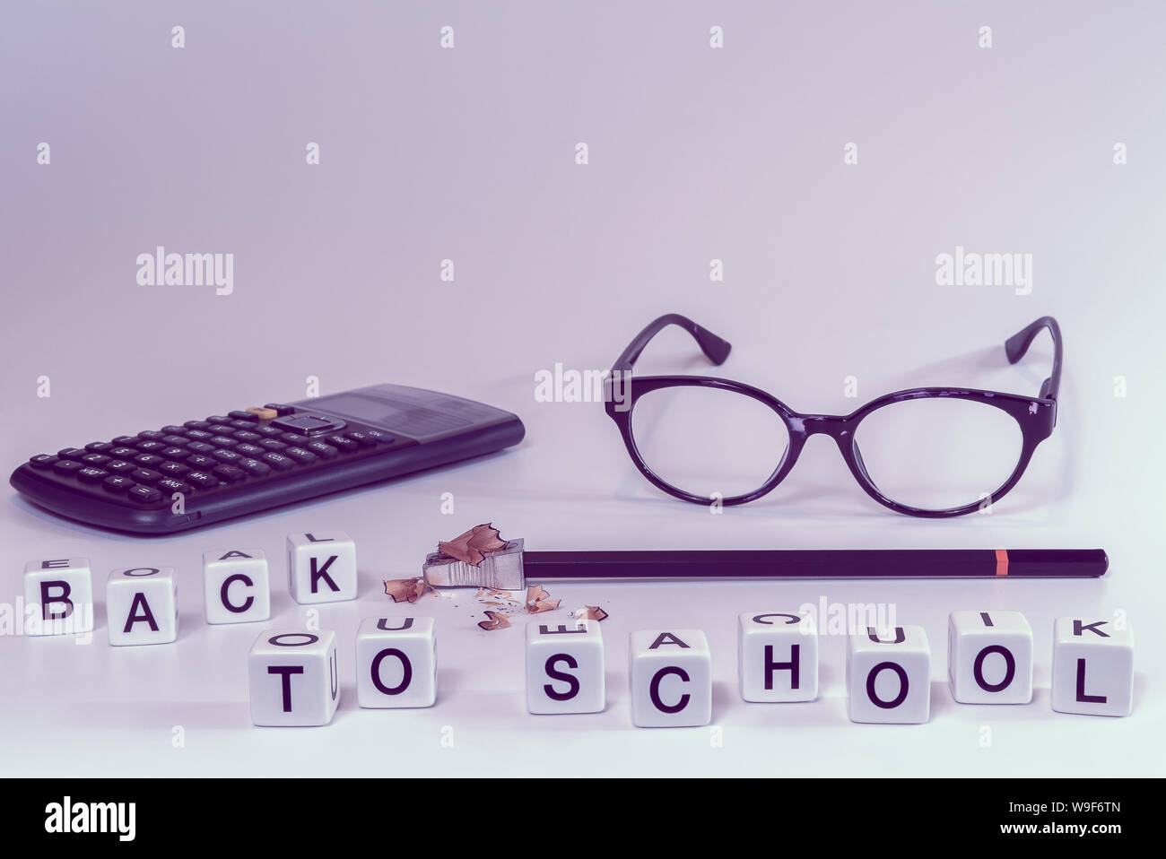 Front view of school supplies with letters spelling the words back to school in girly pink color tones - Concept of college student, university Stock Photo