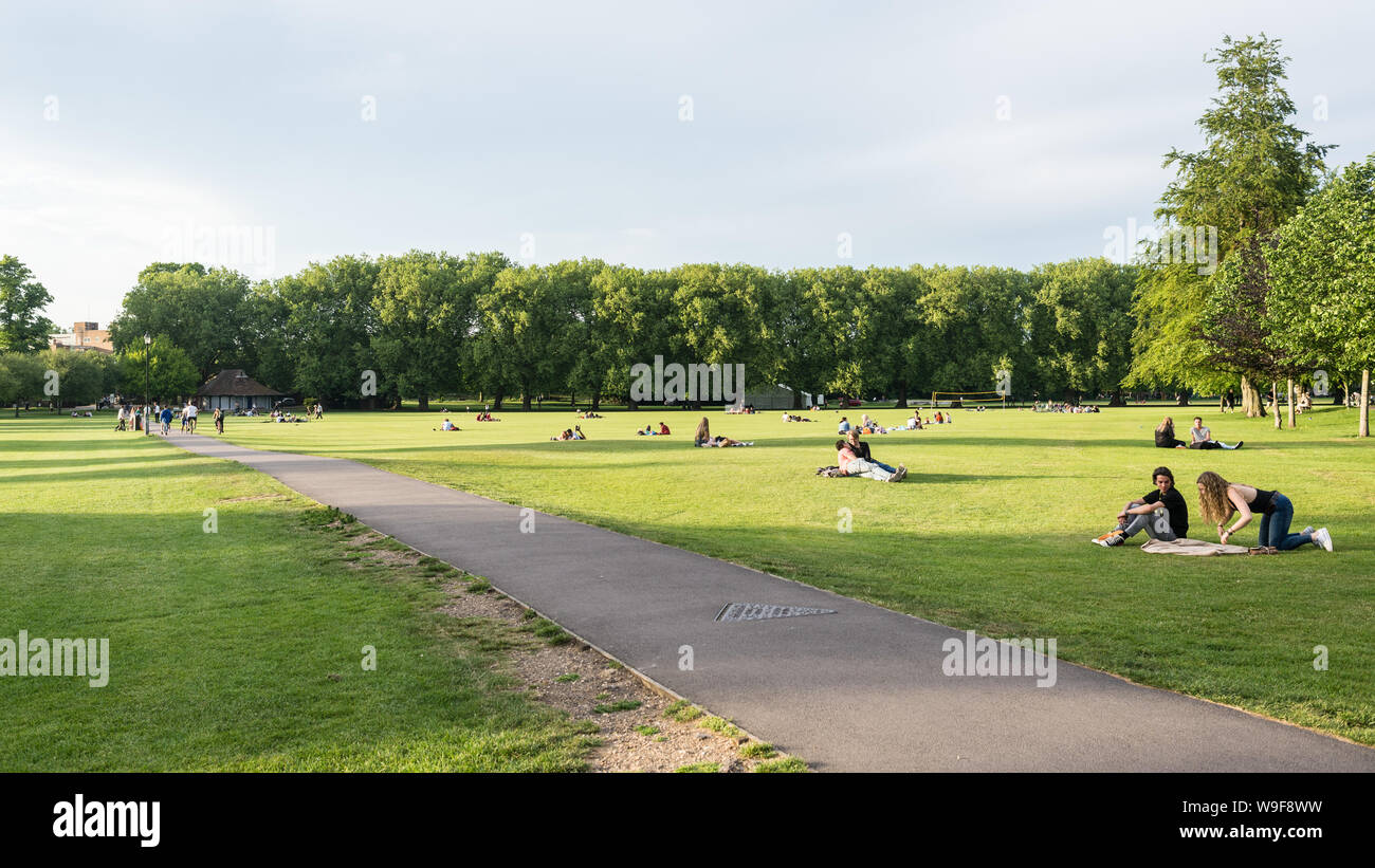 Cambridge, UK - June 2019: People enjoying the warm summer weather in Jesus Green public park, Cambridge, UK. Stock Photo