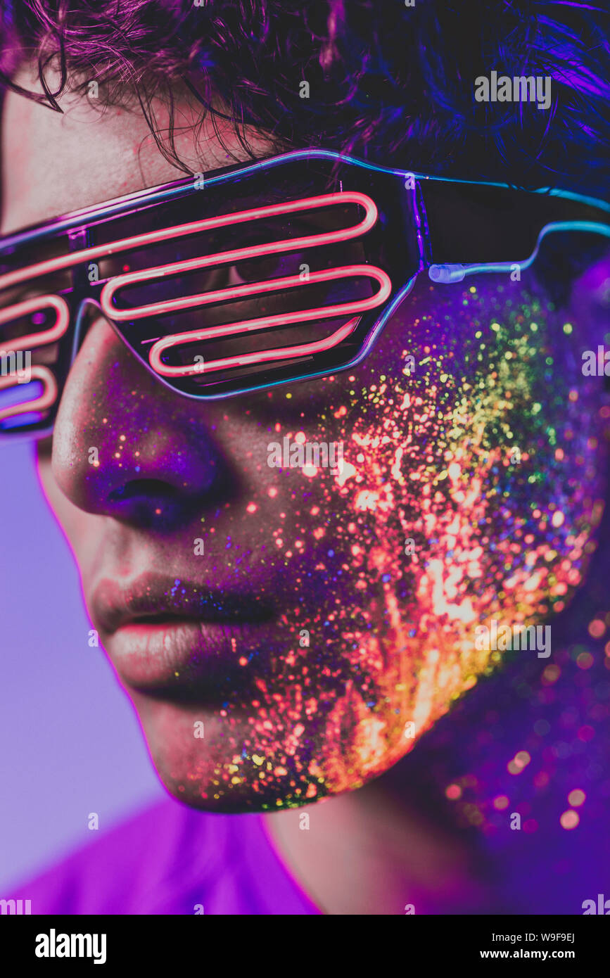 Handsome boy dancing at the rave party with fluorescent paintings on ...