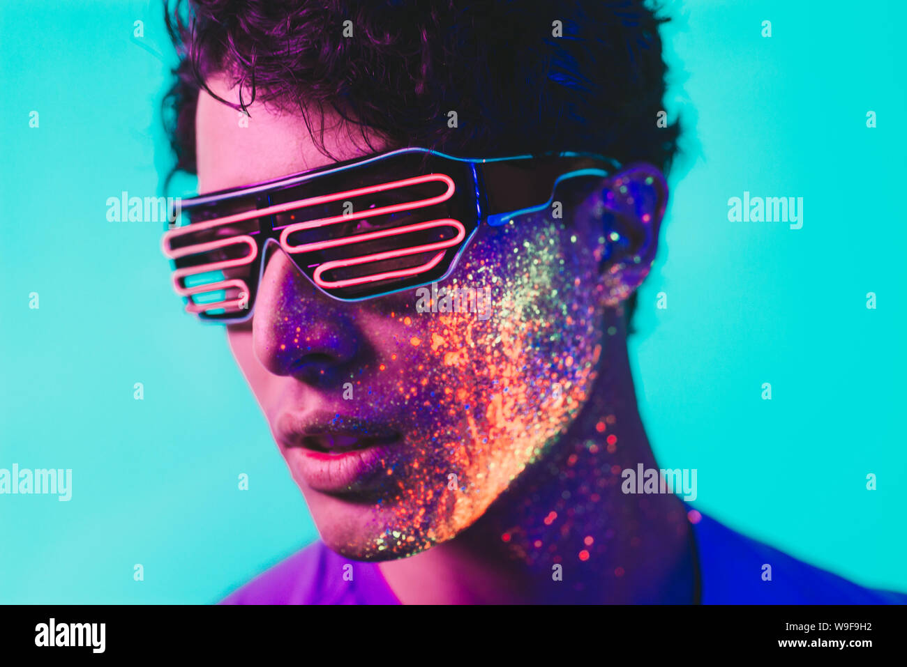 Handsome boy dancing at the rave party with fluorescent paintings on ...